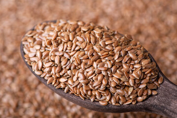 Linen grain in wooden spoon. Macro detail shot of linen grain in dark wooden spoon