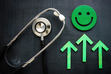Smiley, green arrows and stethoscope as symbol of patient satisfaction.