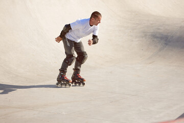 One man, male roller skater on rollerblades training at modern skate park, outdoors. Action,...