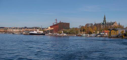 Fototapeta na wymiar Museum building and boats at the pier Galärvarvet a colorful autumn day in Stockholm