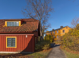 Fototapeta na wymiar Old 1700s color full, wood houses a colorful autumn day in Stockholm