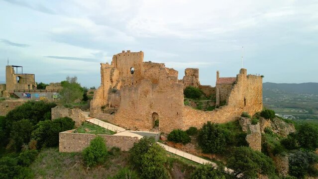 Ruined castle in Europe aerial footage cinematic medieval era Circular flight with very soft sunset light Palafolls castle in Barcelona