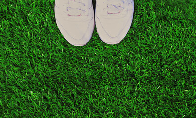 Close up summer sports sneakers on green grass background, top view