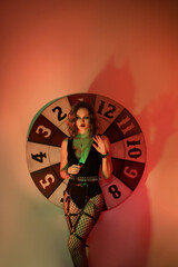 Girl in a sexy costume with a knife and a shadow with horns. halloween image