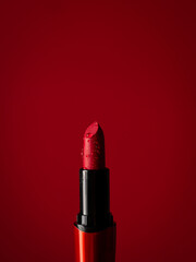 close-up on red lipstick in splashes of water on a red background