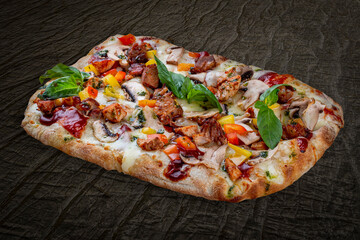 BBQ pizza with pork, chicken, bell pepper, barbecue sauce, mushroom, pesto. Roman pizza rectangular on wood background