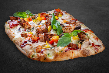 BBQ pizza with pork, chicken, bell pepper, barbecue sauce, mushroom, pesto. Roman pizza rectangular on dark background