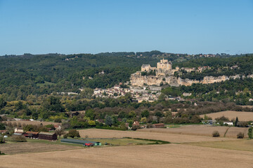 Obraz premium Chateau de Beynac built on top of a limestone cliff, dominating the town of Beynac-et-Cazenac and the North bank of the Dordogne, blue sky