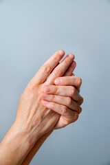 Woman hands touching each other, skin care concept, neutral background, space for copy.