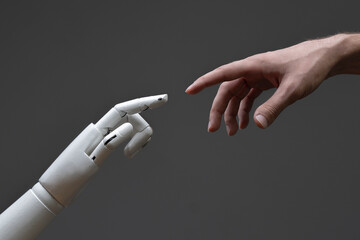 robotic arm touching human hand, man and machine friendship