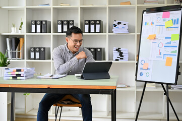 Cheerful adult Asian male financial analyst happy with his financial analysis results.