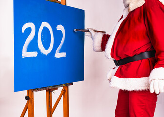 Happy New Year 2023- holiday greeting. Santa Claus in the image of an artist writes the numbers 202.