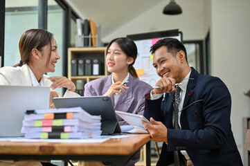 Group of millennial Asian businesspeople enjoy working together, having a nice conversation