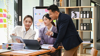Professional male boss training his employees on analyzing financial data in the office.