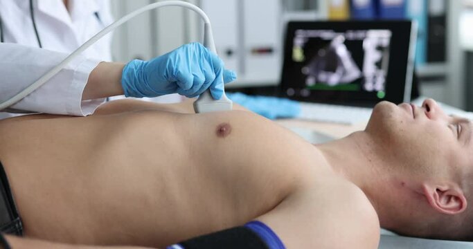 Doctor places ultrasound probe on chest of male patient