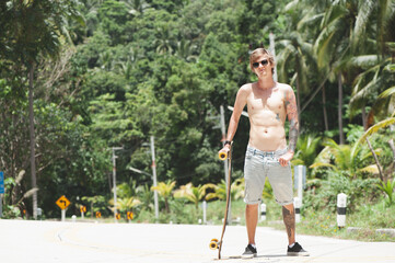 Young adult man with skate board on the road © Natalia