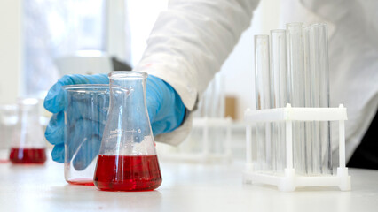 in the laboratory, a laboratory assistant conducts chemical experiments