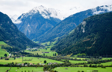 Fototapeta na wymiar Alpenlandschaft mit Wiesen um den Ort Uttendorf