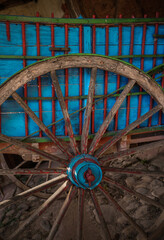 Old cart wheel, in a rustic town in Spain, Vintage style, with old stone and wood background,