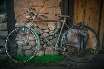 Old bicycle, in a rustic village in Spain, Vintage style, with old stone and wood background