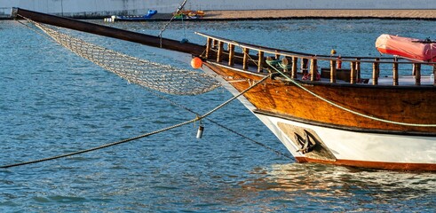 Double-deck pleasure yacht "Gloria" at berth on embankment of Gelendzhik. Close-up of bow of yacht's hull against backdrop of Caucasus Mountains. Gelendzhik, Russia - July 02, 2022
