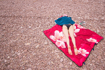 girl lying on the sandy shore of the ocean, resting from the bustle of the city