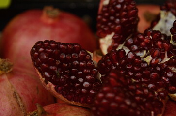 Fresh pomegranate on the market showcaseOpened pomegranate close-up, counter with mixed juice