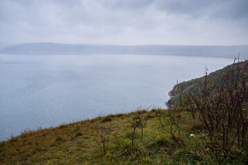 Fjords and cliffs in autumn. Cloudy weather. Mountains and the sea