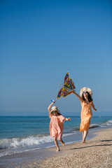 Fototapeta na wymiar Mother and daughter fly a kite on the beach.