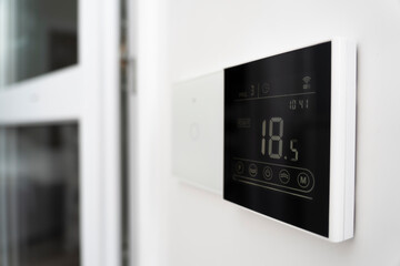 a device for controlling underfloor heating. air conditioner screen on wall that shows an air...