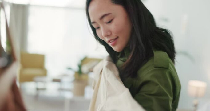 Fashion, clothes and woman in apartment with choice in morning thinking of outfit inspiration for work or career. Happy, excited asian or Japanese girl at home in closet or wardrobe with style idea