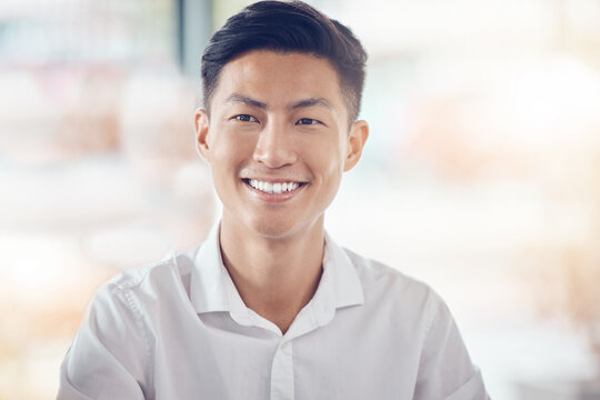 Asian, businessman and portrait smile with happy vision for success against a bokeh background. Successful japanese male smiling with teeth in happiness for company plan, idea or goal at the office