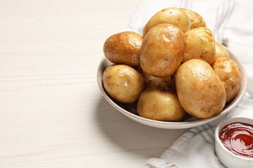 Delicious baked potatoes and tomato sauce on white wooden table, space for text