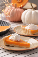 Fresh homemade pumpkin pie with whipped cream on table