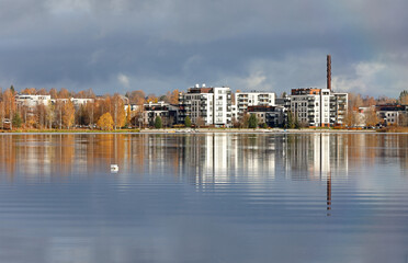 Fototapeta premium Steel blue clouds over a city and a tranquil lake