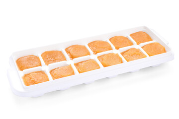 Puree in ice cube tray on white background. Ready for freezing