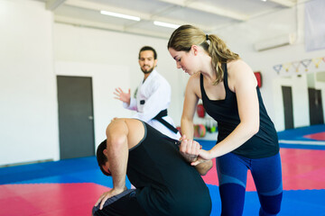 Strong woman fighting an attacker at martial arts school