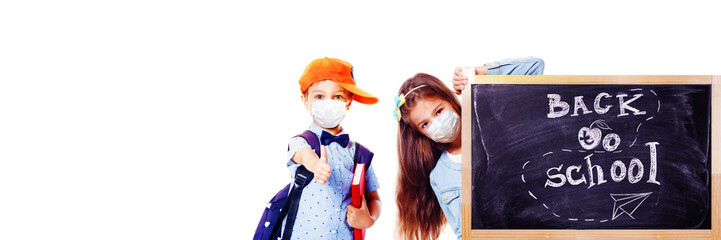 Young children with protection masks against corona virus at school.