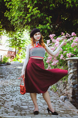 Fashion portrait of young, happy, elegant redhead curly woman, girl in hat and casual clothes. French style. Walking, relax in the city street. Sunny day.