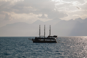 Fototapeta na wymiar Sailboat in the sea against the backdrop of mountains