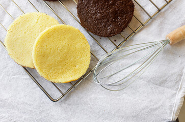 Freshly made homemade sponge cake shortcakes on metallic baking grid,