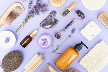 Fototapeta na wymiar Natural bath accessories and self-care lavender products for body and skin care over purple background. Natural lavender cosmetics. Flat lay style