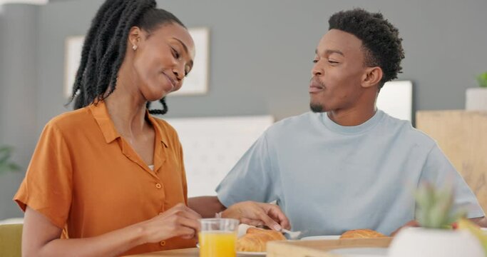 Happy, black couple and breakfast feeding at the dinner table for love, care and share in bonding relationship at home. African American man and woman smiling sharing morning meal together in romance