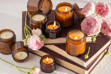 Obraz na płótnie Canvas A set of different aroma candles in brown glass jars. Scented handmade candle. Soy candles are burning in a jar. Aromatherapy and relax in spa and home. Fire in brown jar.