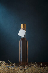 250 ml bottle of pink wine with blank label. Wooden shavings below. Alcohol drink on dark blue...