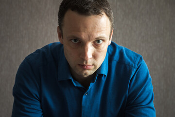 Fototapeta premium Young serious Caucasian man looks at the camera