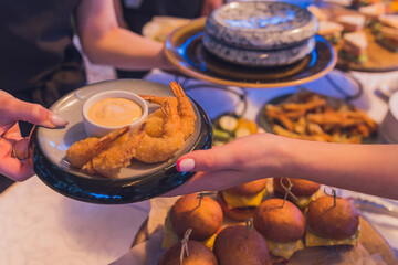Small burgers served on one plate as appetizers.