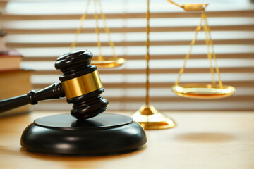 Lawyer or judge's hammer in the court. Auction's hammer and judgement golden scale are on wood table. Law subject. Judgement subject to judge people.