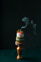 tasty birthday salted cupcake with an extinguished candle on dark background . Vertical