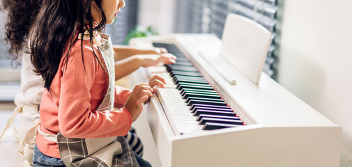 Asian young musician girl kid having fun activities play piano music lesson in music education at home © Art_Photo
